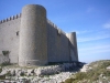 Castell de Montgrí – Torroella de Montgrí - En primer pla veiem les restes d'una pedrera, que al mateix temps va servir per envoltar l'edificació d'un petit fossat