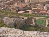 Castell de Biosca - Biosca als peus del castell. En primer terme, restes d'una torre rodona.