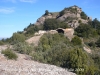 Església de Sant Pau Vell – El Bruc - Al fons de la fotografia el turó on es suposa hi havia el castell de La Guàrdia.