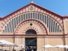 Tortosa - El Mercat. En terrenys guanyats a l’Ebre, sobre el port fluvial des de l’edat mitjana, entre el riu i l’actual avinguda de la Generalitat, s’alça un edifici voluminós, d’aparença elemental i obra brillant, construït entre 1884 i 1887, un dels edificis emblemàtics de la ciutat.  A partir del projecte de Joan Abril, l’execució final del projecte i la solució tècnica de l’estructura de la coberta corresponen a Joan Torras i Guardiola, “l’Eiffel català”. El promotor va ser el Banc de Tortosa. Trenca amb el prototipus de mercat de tres naus, s’estructura en una única nau rectangular, amb simetria absoluta respecte els seus dos eixos, amb teulada a doble vessant i amb una entrada a cada costat, sent-ne les principals les corresponents als costats curts.  Si l’exterior és cridaner i efectiu, amb evocacions a portades i contraforts del romànic català, merlets del gòtic i decoració que prediu el modernisme, el seu interior destaca per una admirable audàcia en l’estructura que suporta la coberta. Per tal de salvar l’amplada considerable, tot mantenint l’espai interior diàfan, l’autor emprà 14 estructures metàl·liques de ferro i perfil parabòlic, a mode d’arcs de diafragma que, a més a més, redueixen les empentes laterals. Font: Tortosa turisme.